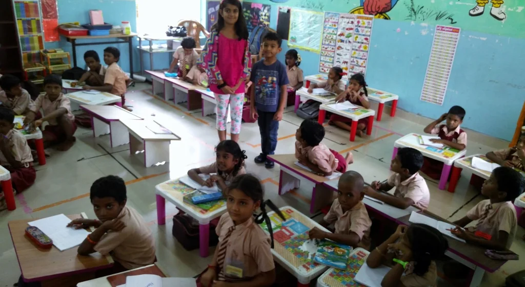 Children sit with books in an Arumbakkam school classroom.